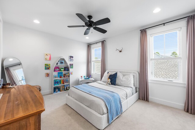 carpeted bedroom featuring ceiling fan and multiple windows