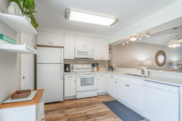 kitchen featuring sink, white appliances, light hardwood / wood-style floors, white cabinets, and kitchen peninsula