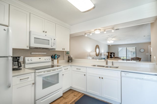 kitchen with sink, white cabinets, white appliances, and kitchen peninsula