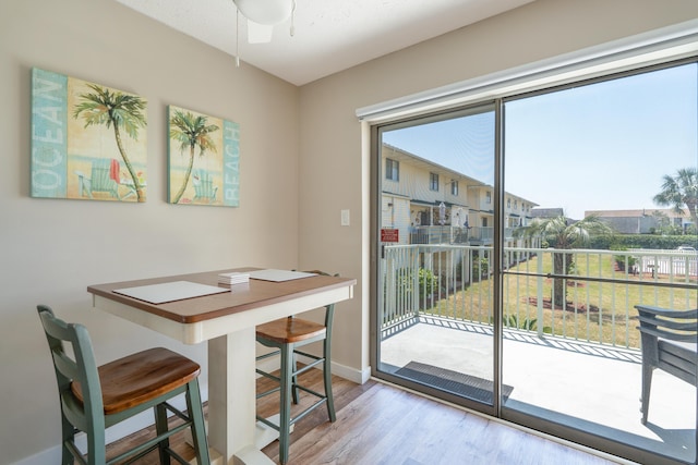 dining space featuring wood-type flooring and ceiling fan