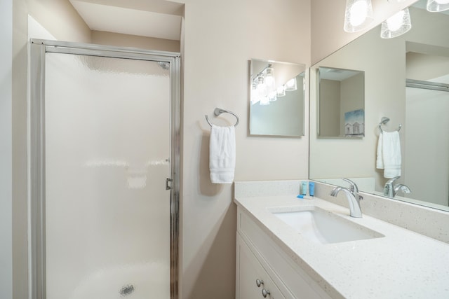 bathroom with a shower with door and vanity