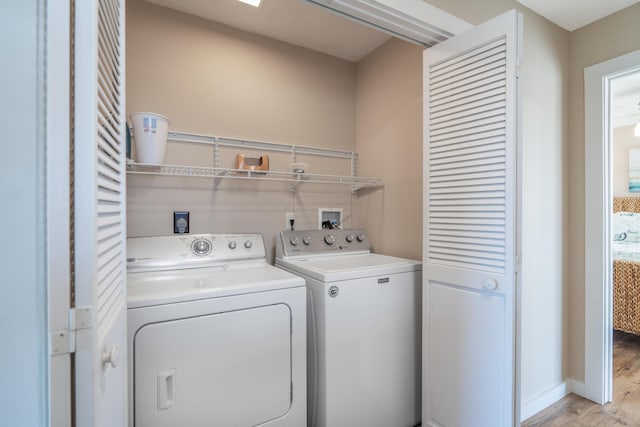 laundry area with separate washer and dryer and light wood-type flooring