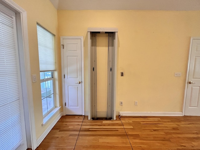 unfurnished bedroom with elevator and light hardwood / wood-style flooring