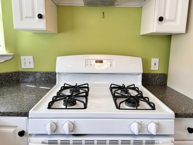 room details featuring white range with gas cooktop and white cabinets