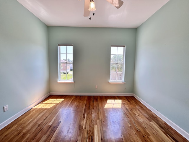 empty room with hardwood / wood-style flooring and ceiling fan