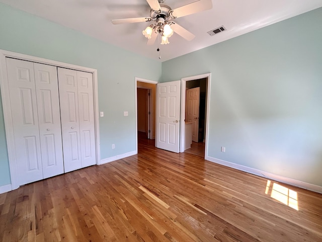 unfurnished bedroom featuring hardwood / wood-style flooring, ceiling fan, and a closet