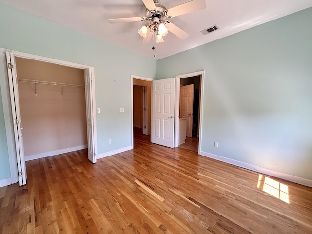 unfurnished bedroom featuring hardwood / wood-style flooring, a closet, and ceiling fan