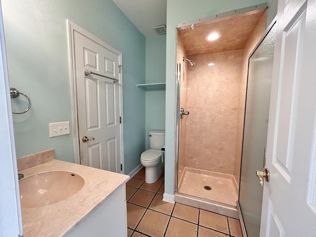 bathroom featuring tiled shower, vanity, toilet, and tile patterned flooring