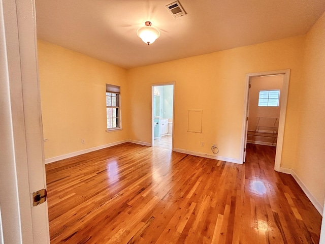 empty room with light hardwood / wood-style flooring and a wealth of natural light