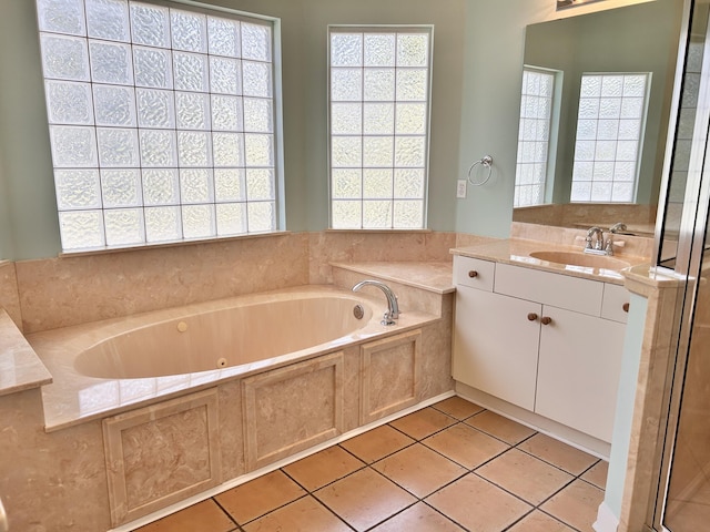 bathroom featuring tiled tub, vanity, and tile patterned floors