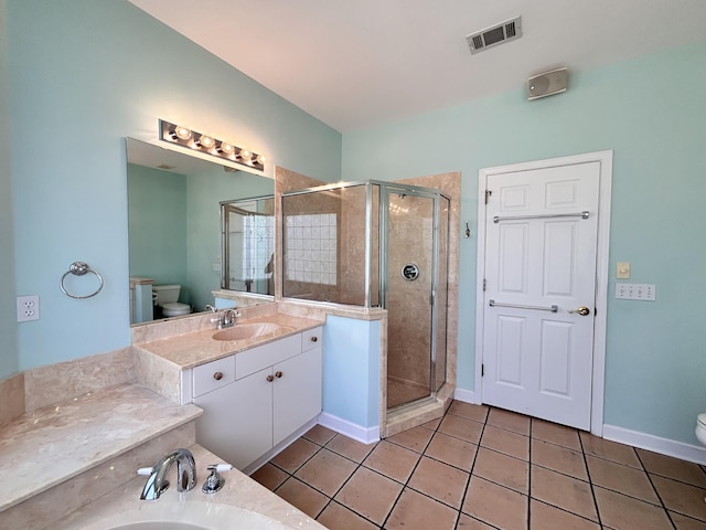 bathroom featuring vanity, a shower with shower door, tile patterned floors, and toilet