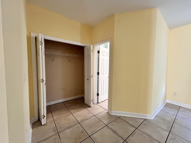 unfurnished bedroom featuring light tile patterned flooring and a closet