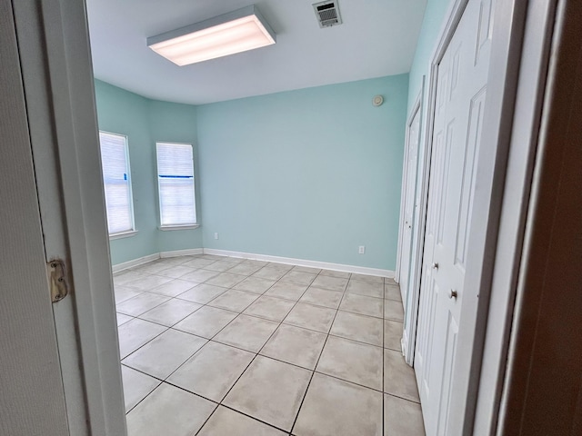 unfurnished bedroom with light tile patterned floors and a closet