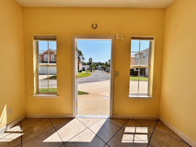 entryway with a healthy amount of sunlight and light tile patterned floors