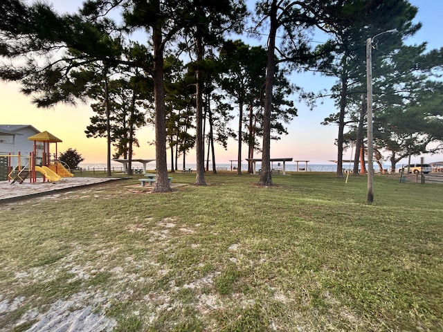 yard at dusk featuring a playground