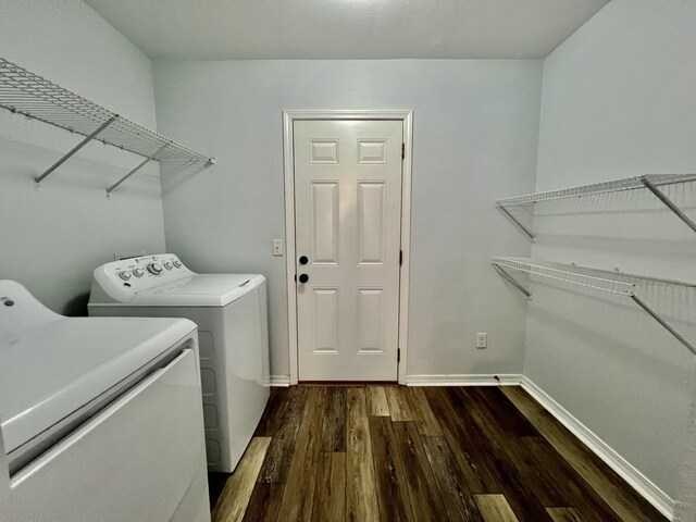 clothes washing area with dark wood-type flooring and independent washer and dryer