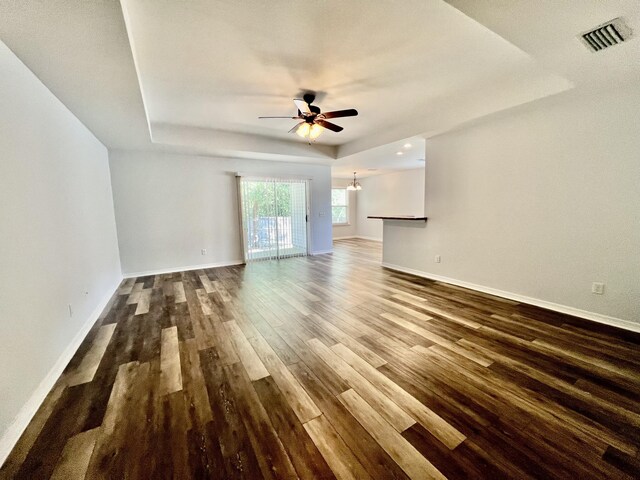 interior space featuring ceiling fan, dark hardwood / wood-style flooring, and a tray ceiling