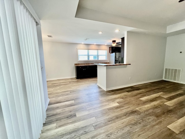 unfurnished living room with wood-type flooring and ceiling fan