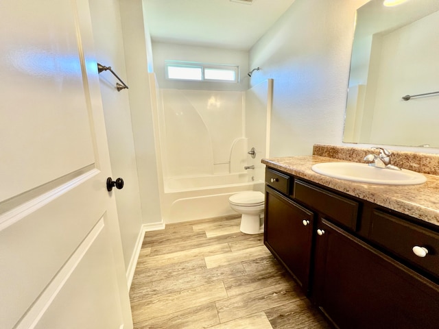 full bathroom with shower / washtub combination, toilet, hardwood / wood-style floors, and vanity