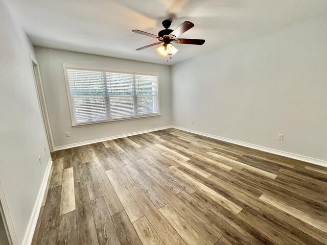 empty room with hardwood / wood-style flooring and ceiling fan