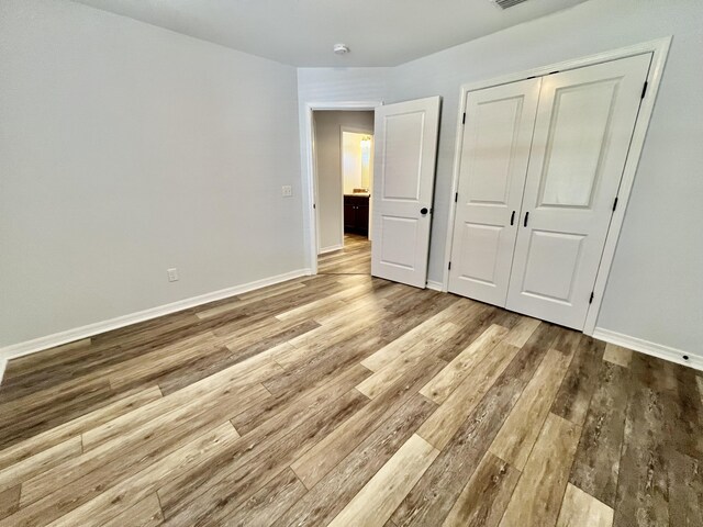 unfurnished bedroom featuring light hardwood / wood-style floors and a closet