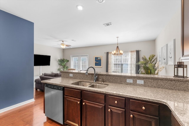 kitchen featuring sink, light wood-type flooring, ceiling fan with notable chandelier, dishwasher, and pendant lighting