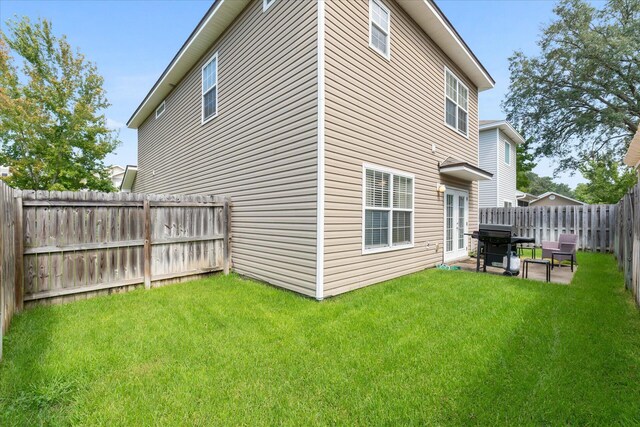 rear view of house featuring a lawn and a patio area