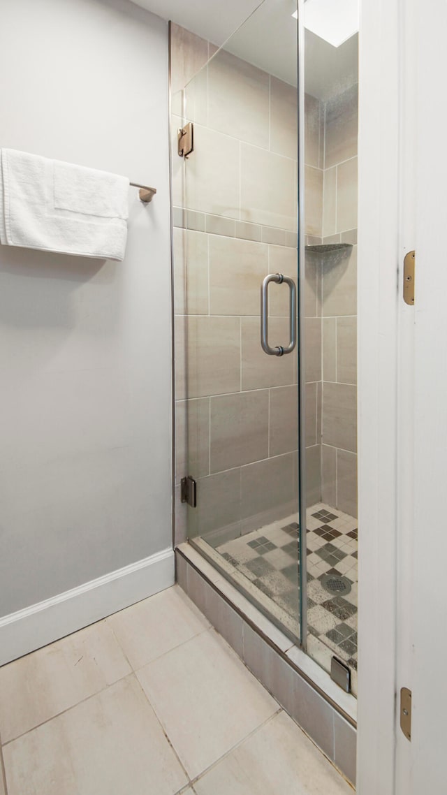 bathroom featuring tile patterned flooring and a shower with shower door