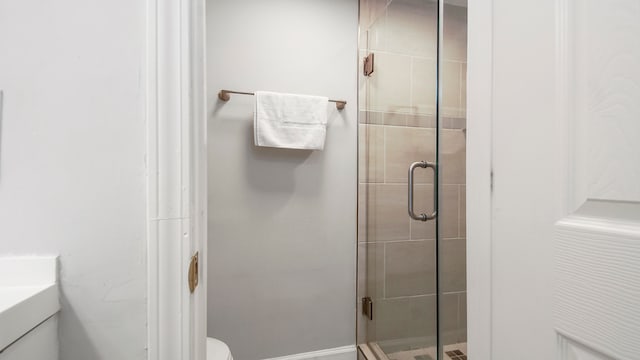 bathroom with an enclosed shower, toilet, and vanity