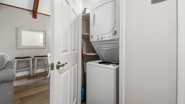 clothes washing area featuring hardwood / wood-style floors and stacked washer / dryer