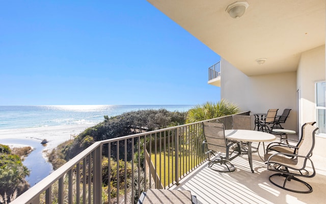 balcony featuring a beach view and a water view