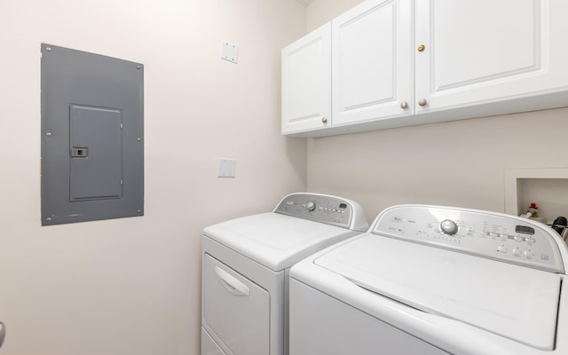 laundry room featuring cabinets, electric panel, and washer and dryer