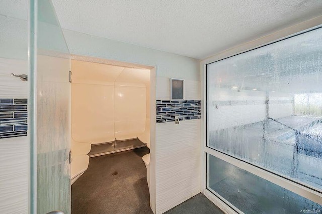 bathroom with tile walls and a textured ceiling