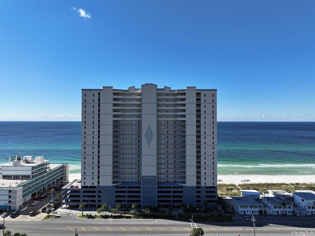 view of building exterior featuring a beach view and a water view