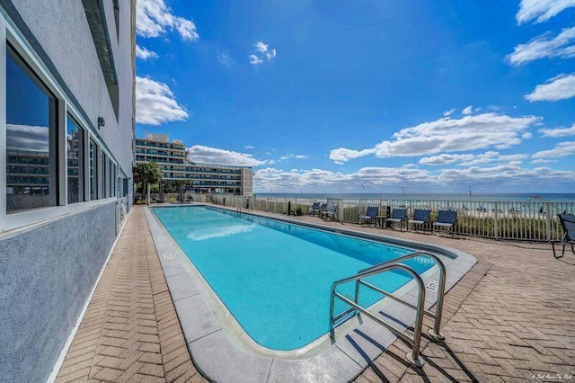 view of swimming pool featuring a patio area and a water view