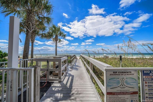 view of property's community featuring a beach view and a water view