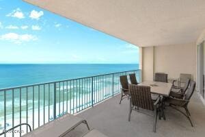 balcony with a water view and a beach view