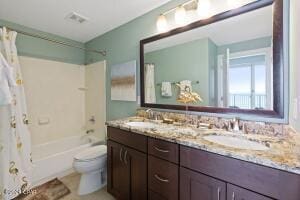 full bathroom featuring vanity, toilet, and shower / tub combo with curtain