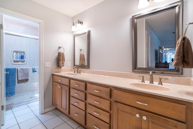 bathroom featuring tile patterned floors, double sink vanity, a textured ceiling, and walk in shower