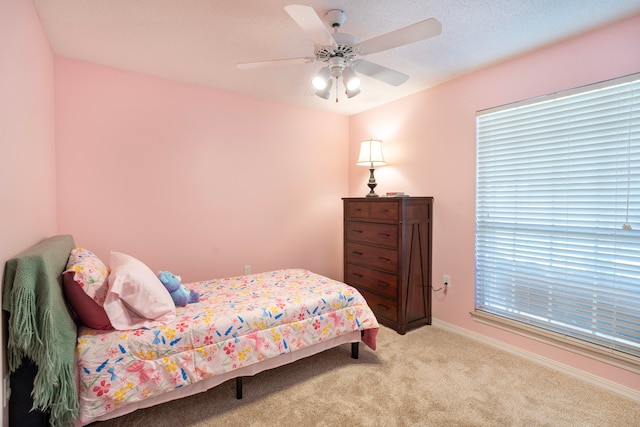 bedroom with ceiling fan and light carpet