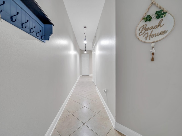 hallway featuring baseboards and light tile patterned floors