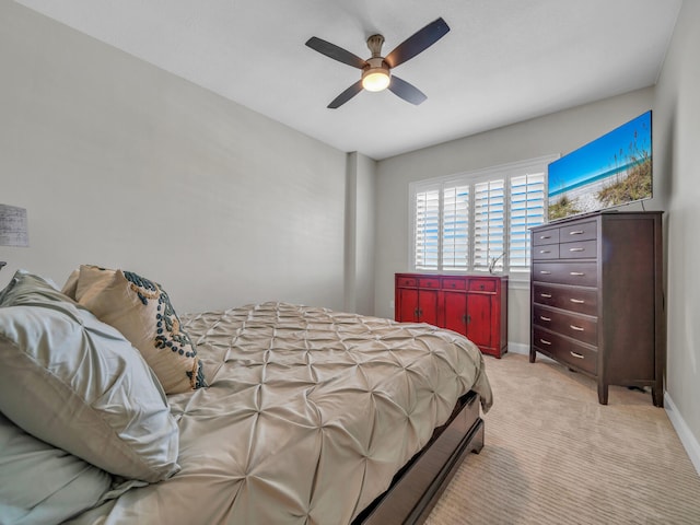 bedroom featuring baseboards, a ceiling fan, and light colored carpet