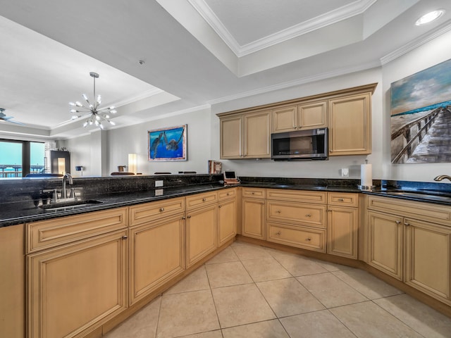 kitchen featuring light tile patterned floors, stainless steel microwave, a raised ceiling, and a sink