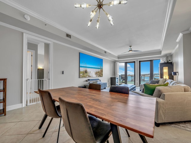 dining area featuring light tile patterned floors, visible vents, a raised ceiling, ornamental molding, and ceiling fan with notable chandelier