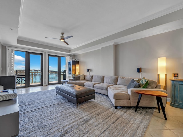 living room featuring light tile patterned floors, a ceiling fan, a raised ceiling, and crown molding