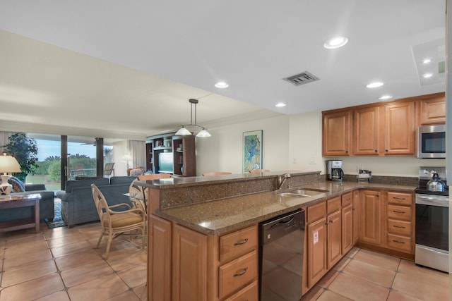 kitchen featuring visible vents, decorative light fixtures, a peninsula, stainless steel appliances, and a sink