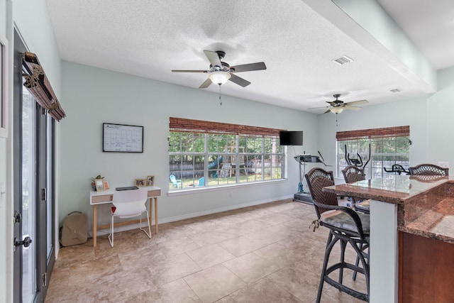 tiled dining space featuring ceiling fan and a textured ceiling