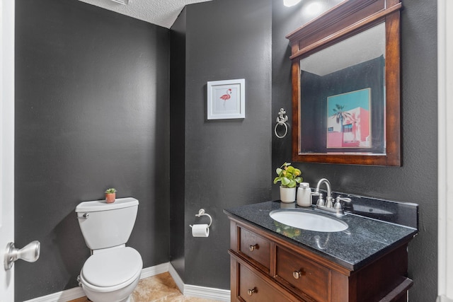 bathroom with tile patterned flooring, toilet, a textured ceiling, and vanity