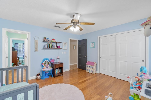 bedroom featuring light wood-type flooring, ceiling fan, and a closet