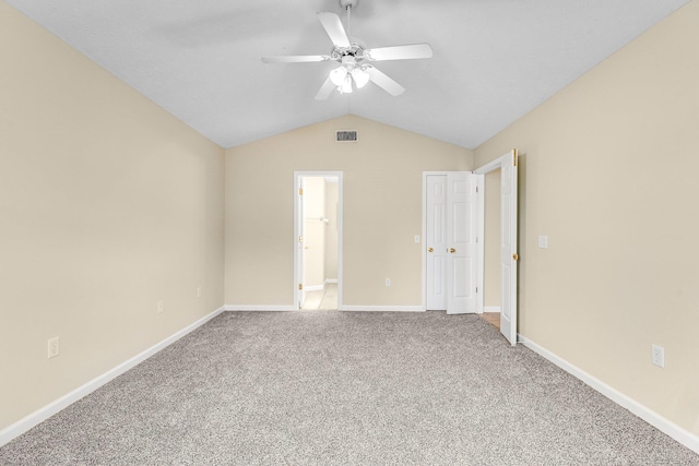 unfurnished bedroom featuring vaulted ceiling, carpet, ensuite bathroom, and ceiling fan